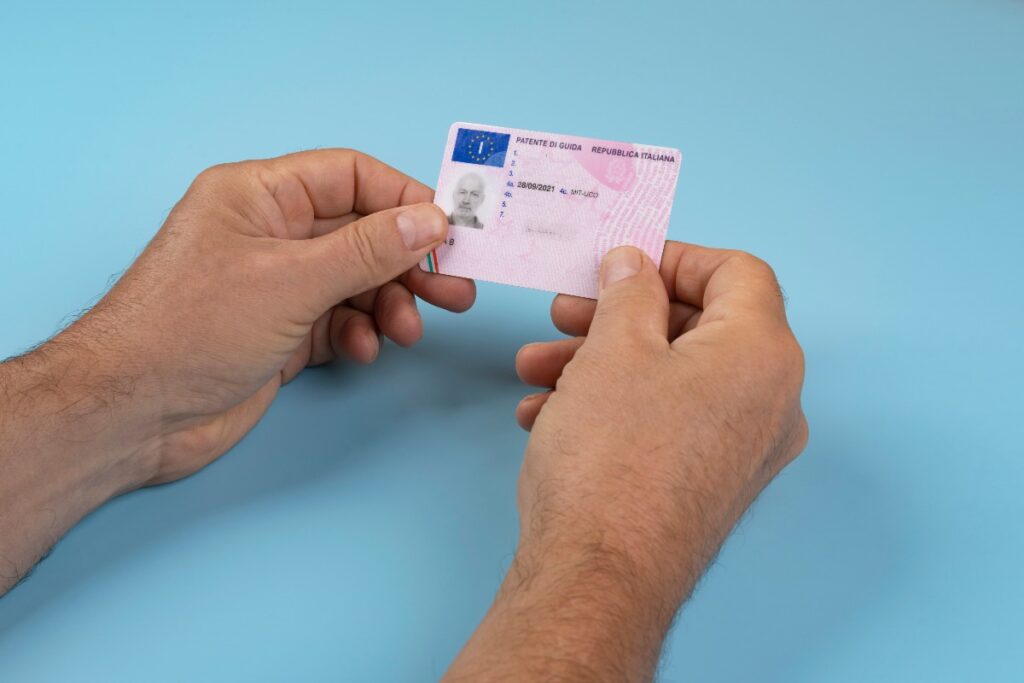 un homme avec un permis de conduire italien entre les mains